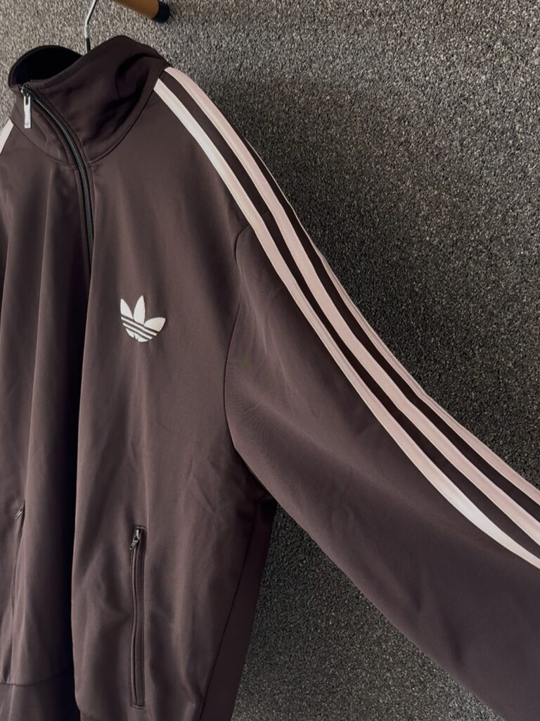 ピンクラインが入ったadidas Originalsトラックジャケットのロゴディテール